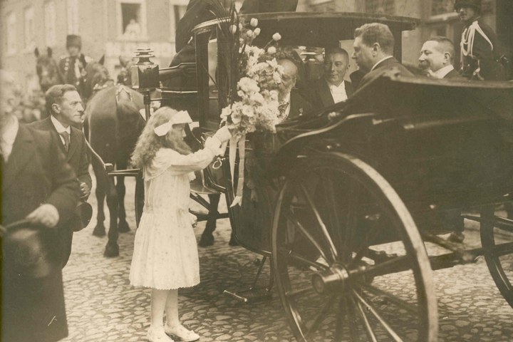 Een bruidje biedt Dr. P.J.H. Cuypers  bloemen aan bij gelegenheid van zijn 90e verjaardag Dr. P.J.H. Cuypers